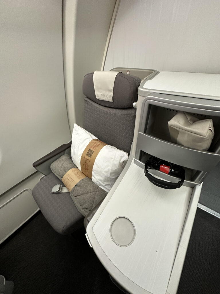 a seat with pillows and a tray on the side