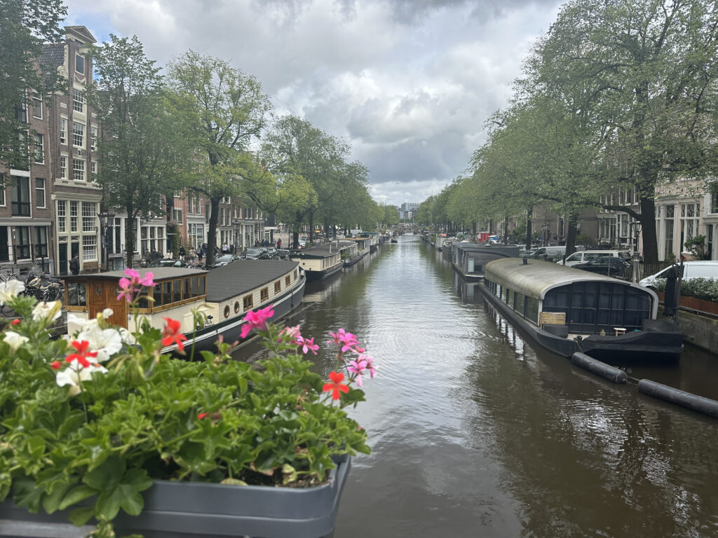 a canal with boats and flowers