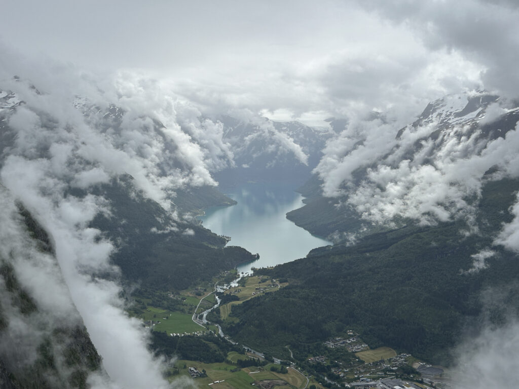a river between mountains with clouds