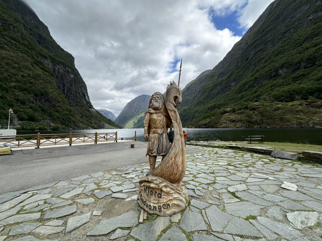 a statue of a man with a sword and a boat on a stone path
