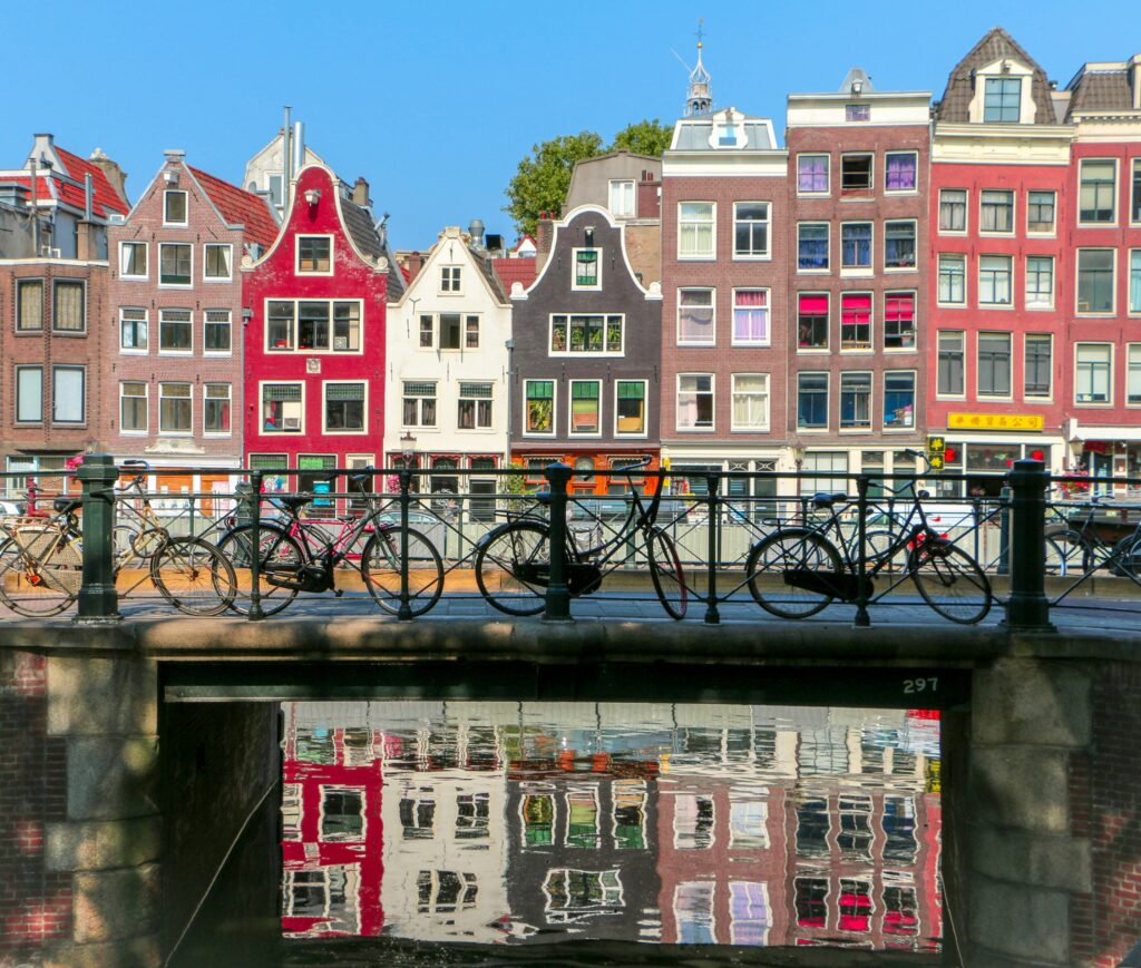 a bridge with bicycles on it and buildings in the background