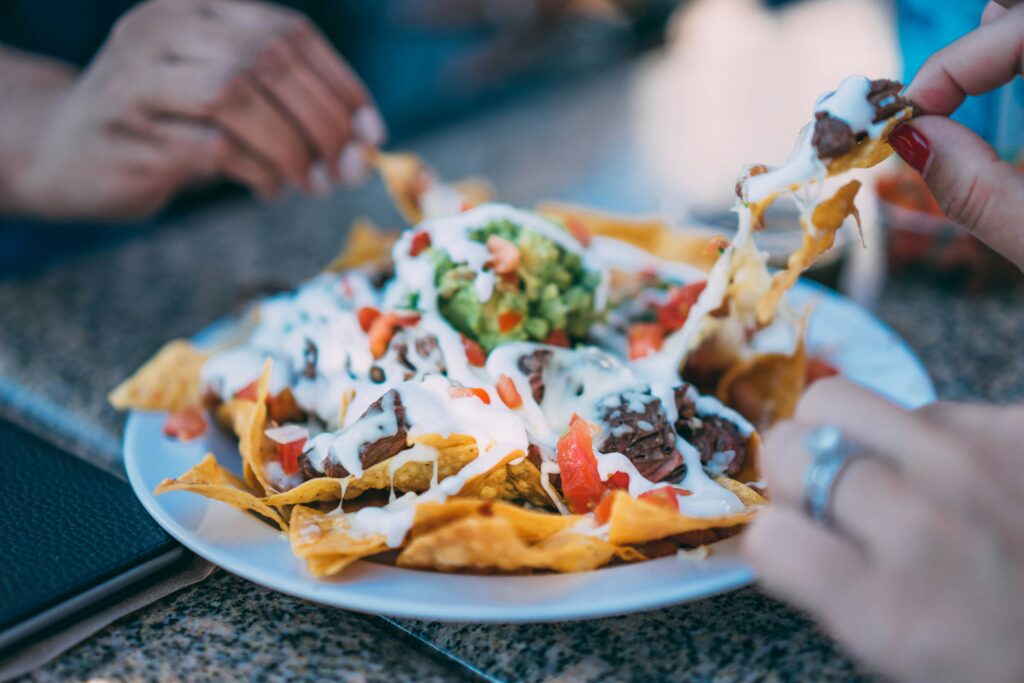 a plate of nachos with sauce and meat