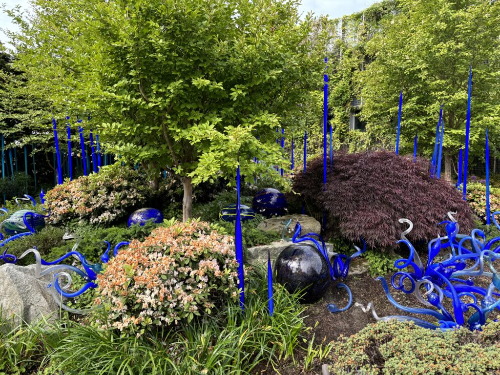 a garden with blue glass sculptures