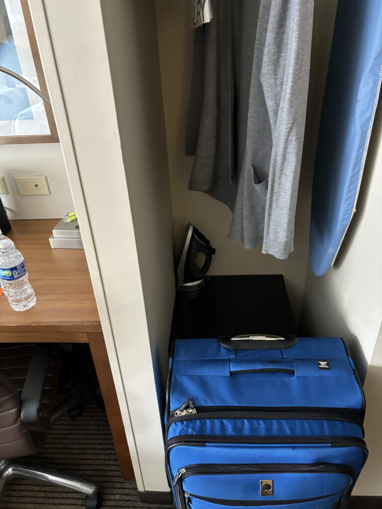 a blue suitcase next to a desk
