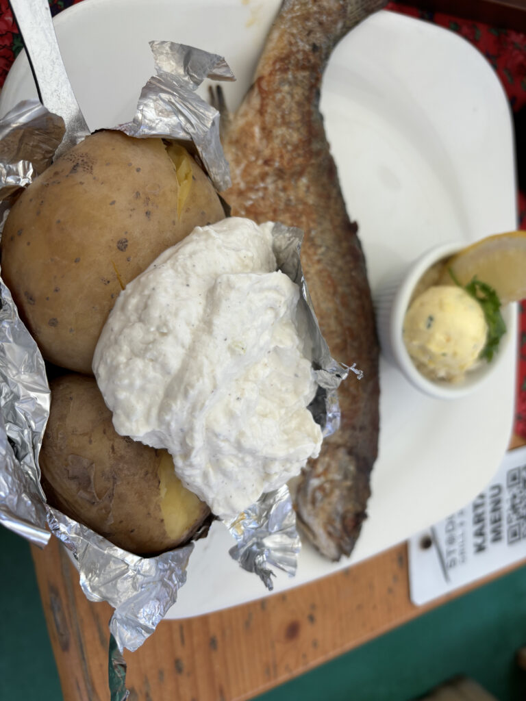a plate of food with a fish and potatoes