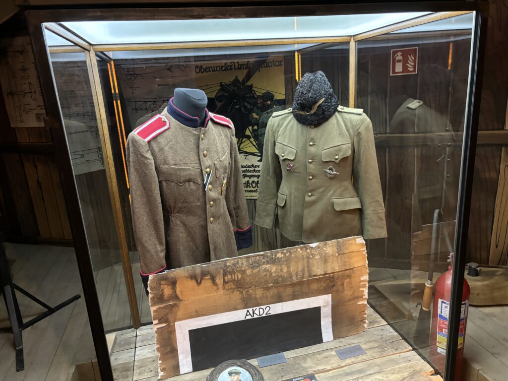 a display case with military uniforms