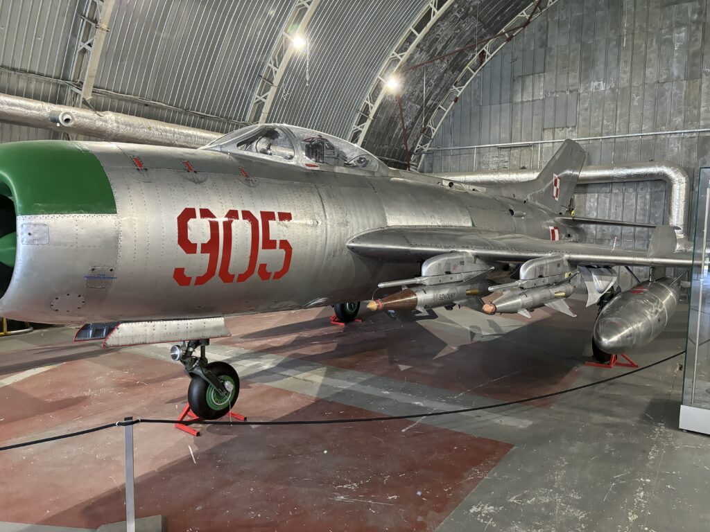 a silver airplane in a hangar