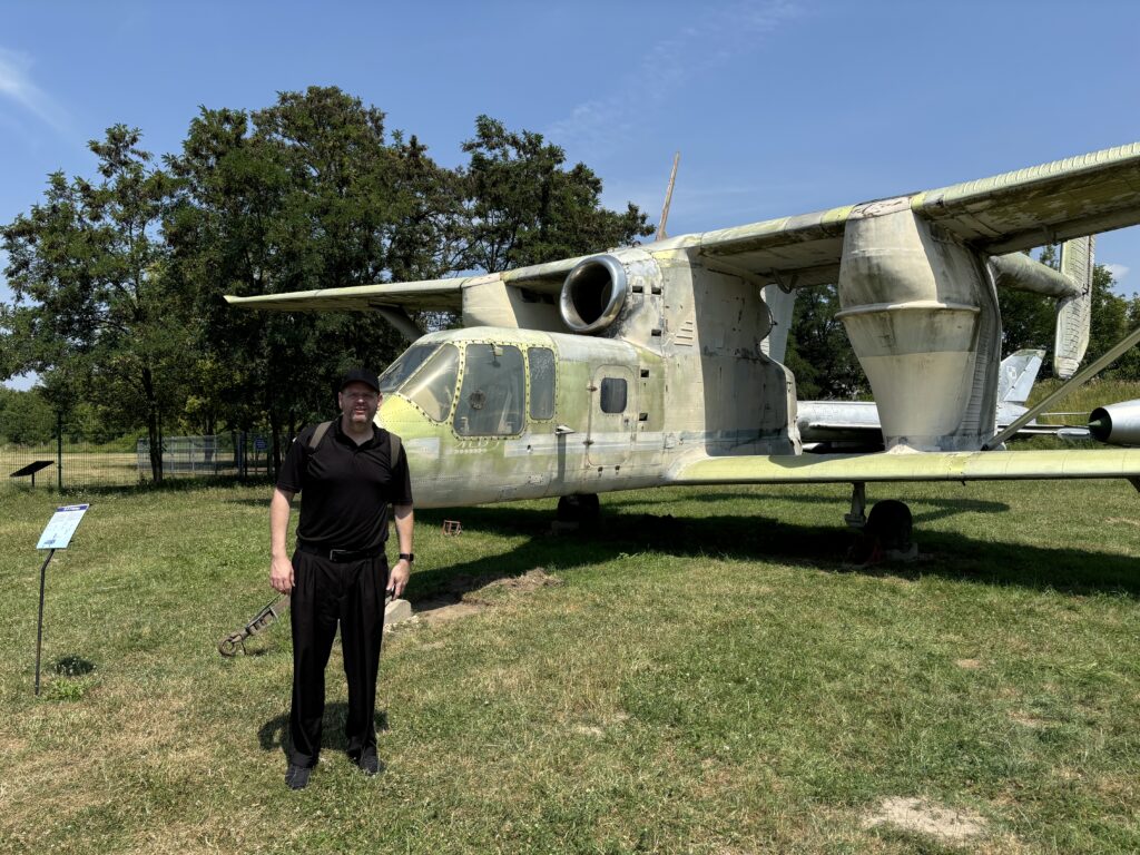 a man standing in front of an old military plane
