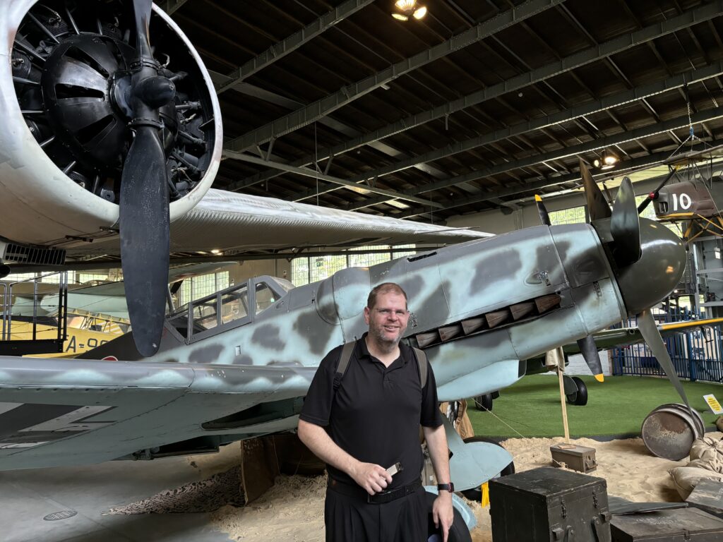 a man standing in a hangar with a plane