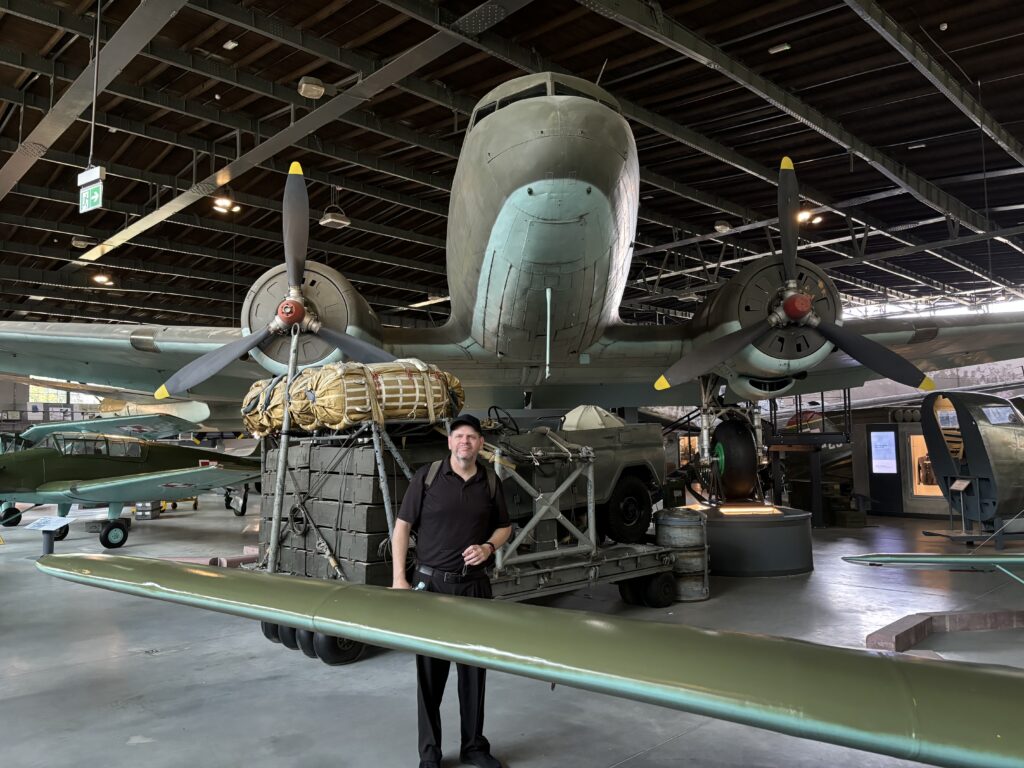 a man standing in a hangar with a plane