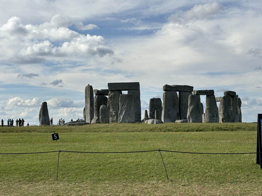 a stonehenge in a grassy field with Stonehenge in the background
