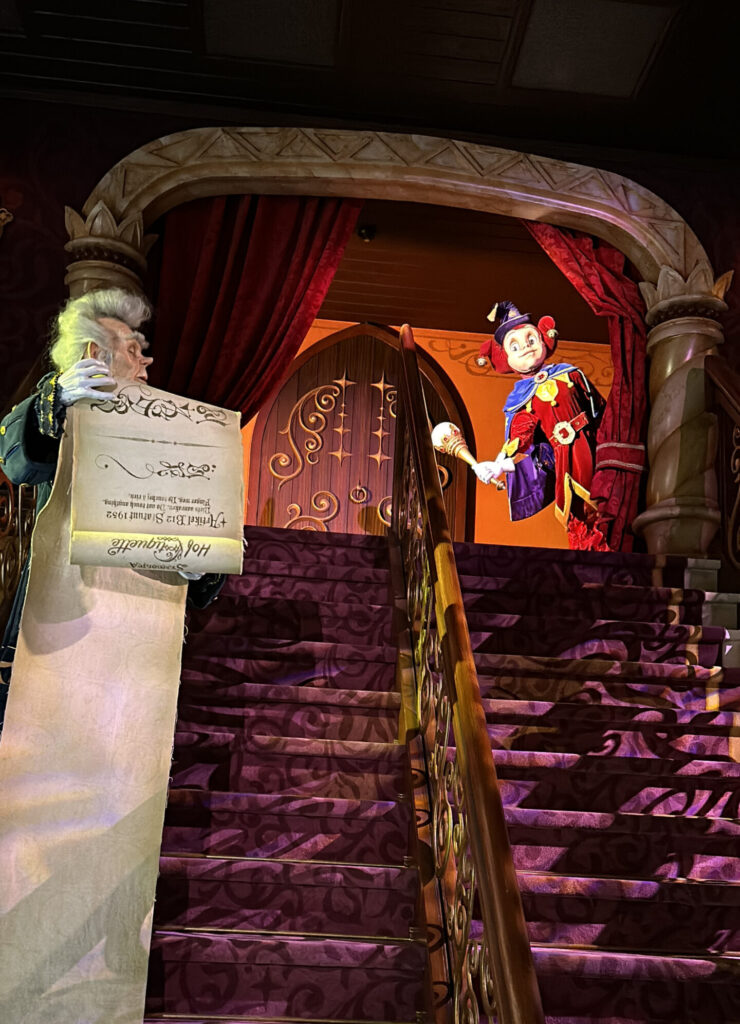 a man holding a scroll and a clown on a staircase
