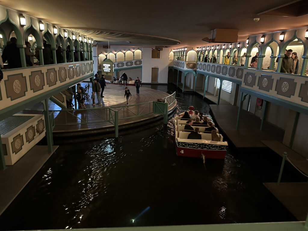 a boat in a canal with people in the background