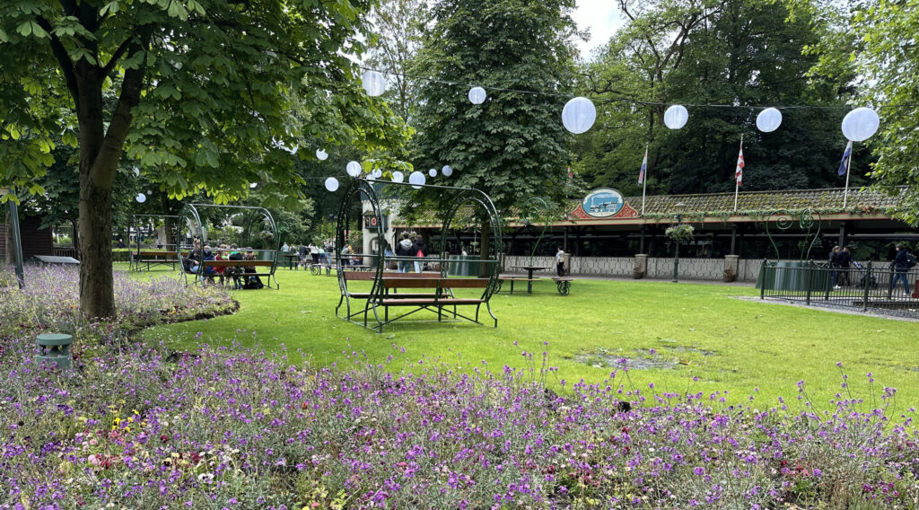 a park with benches and flowers