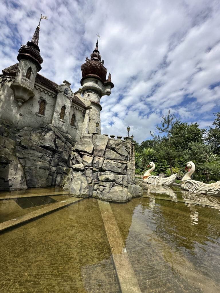 a castle with a pond and swans