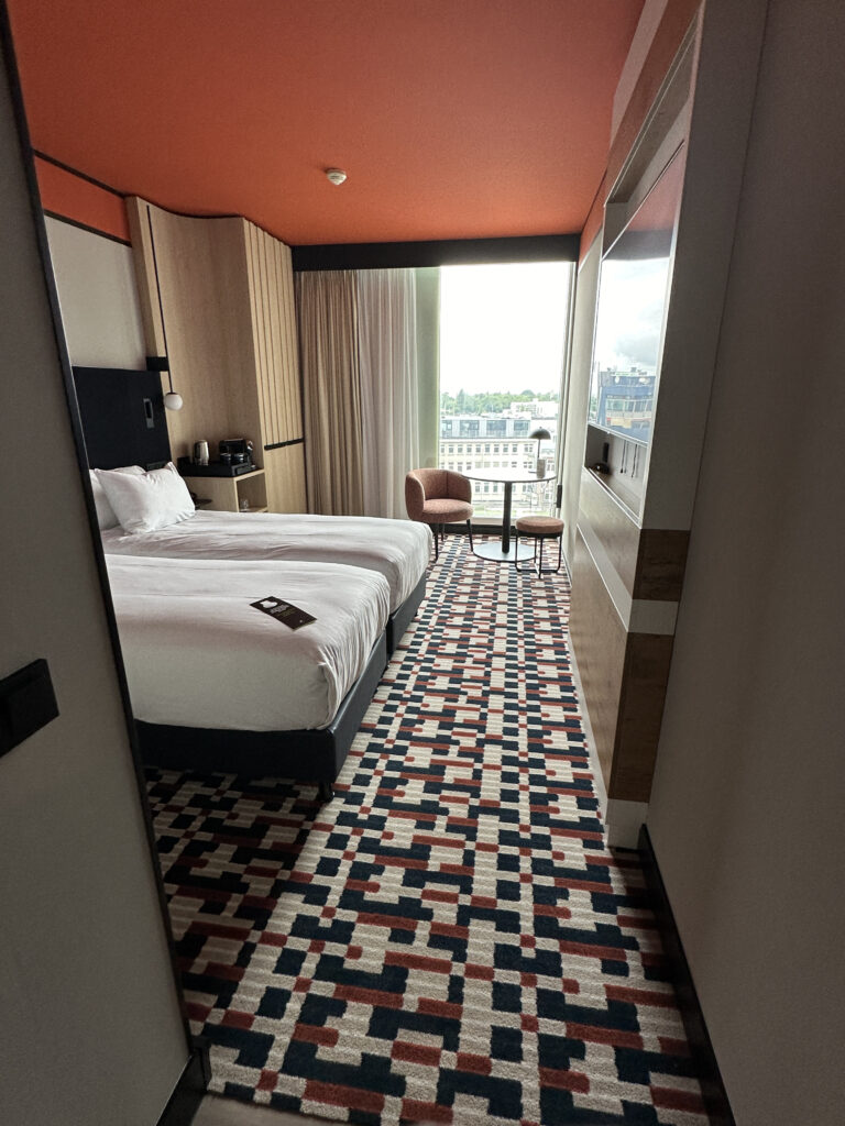 a room with two beds and a chair