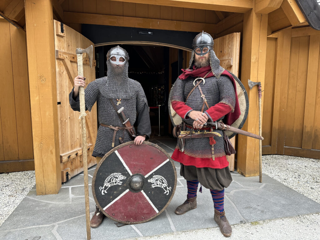 two men wearing armor and holding shields and shields