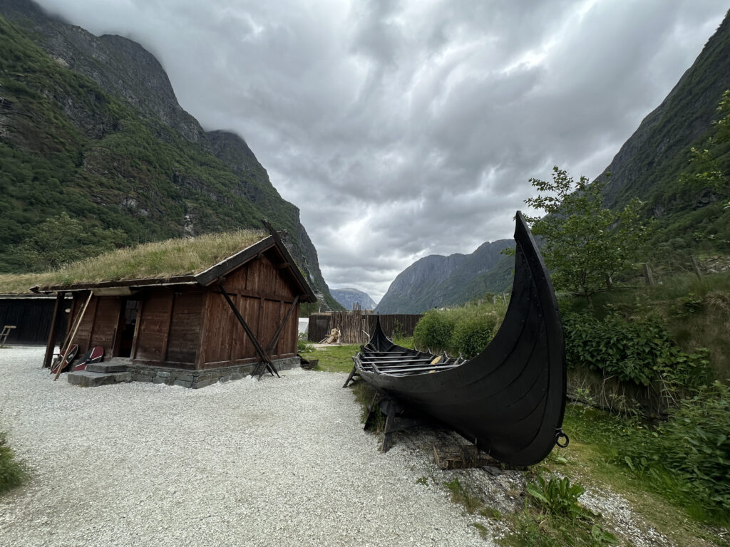 a boat on the shore of a mountain