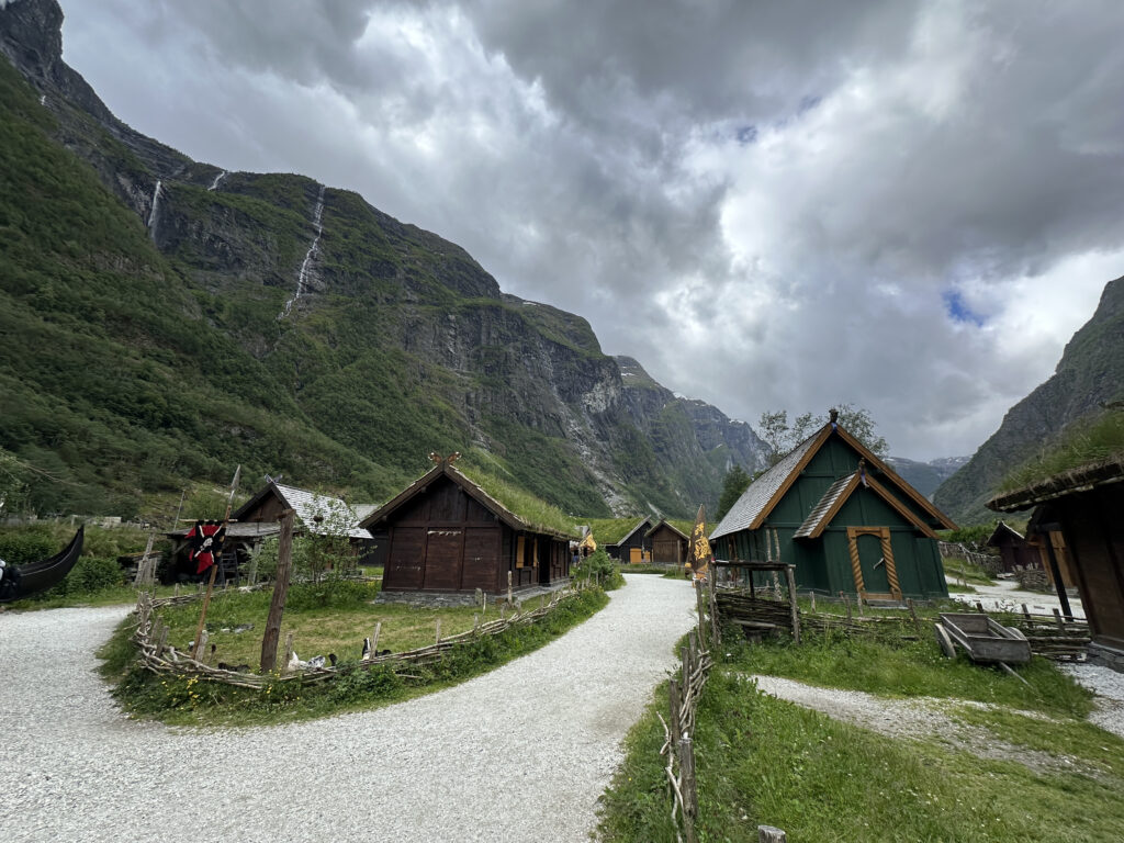 a group of houses in a valley with mountains in the background