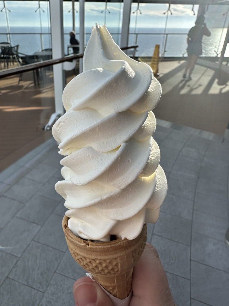 a hand holding a soft serve ice cream cone