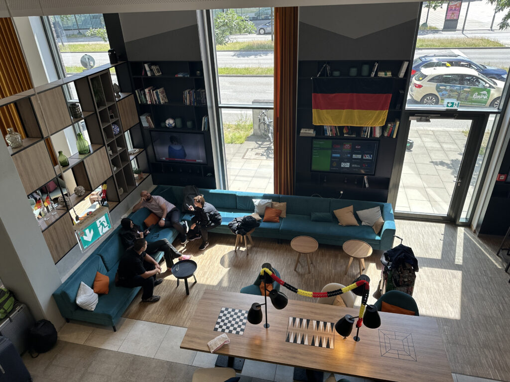 a group of people sitting on a couch in a room with windows