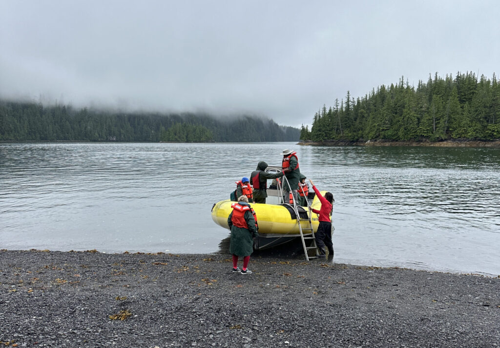 a group of people on a boat on a rocky shore