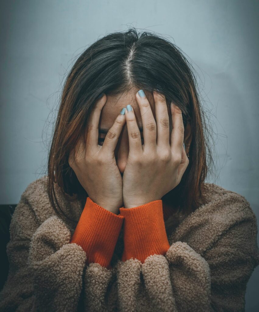 a woman covering her face with her hands