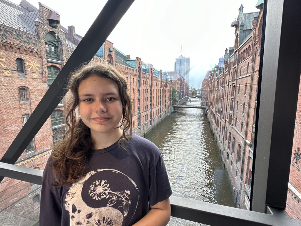 a girl standing in a bridge over a canal