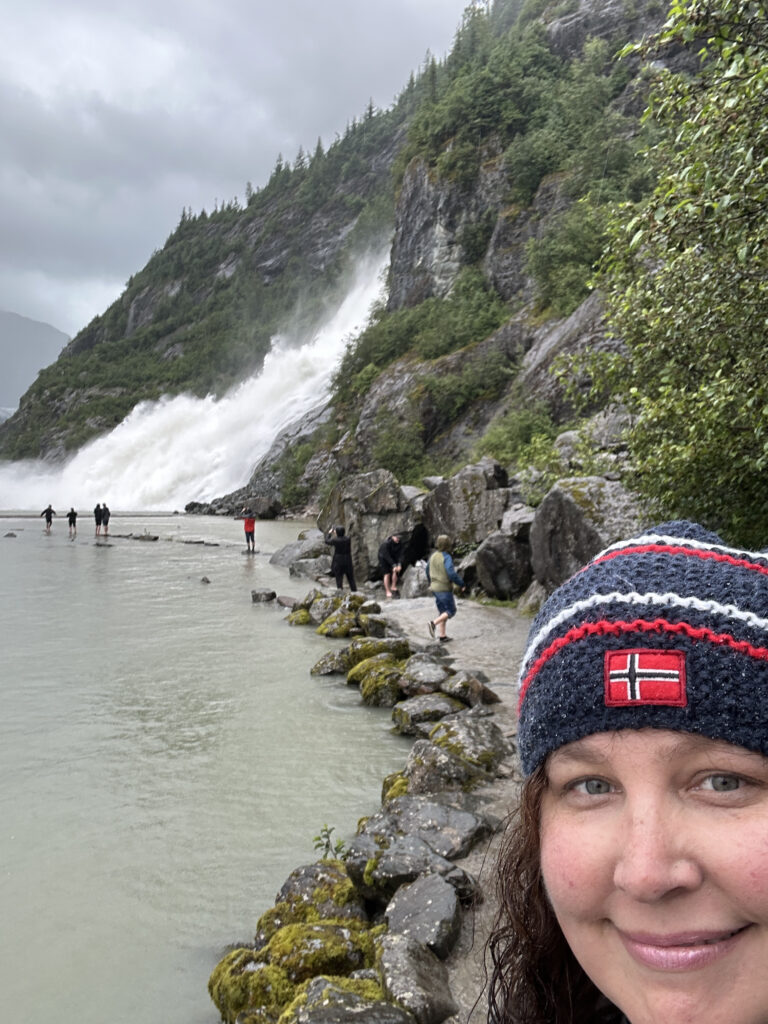 a woman taking a selfie by a waterfall