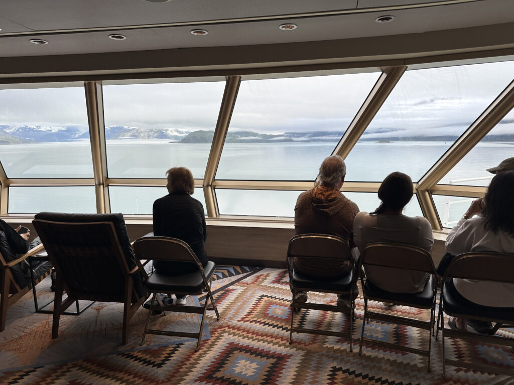 people sitting in chairs looking out a window