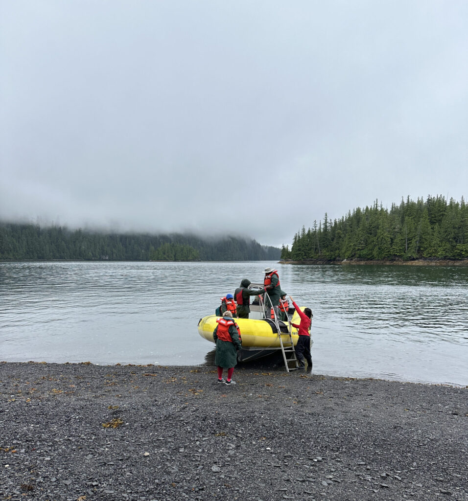 a group of people on a boat on a rocky shore