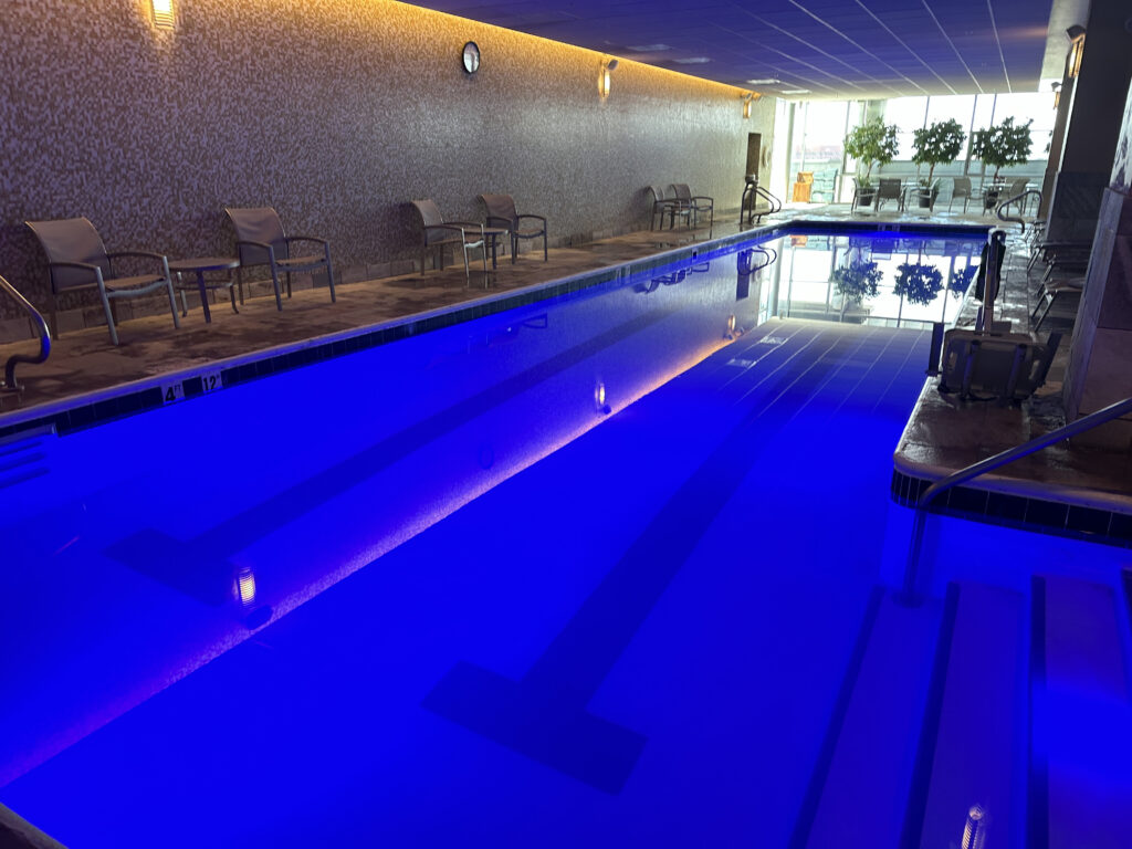 a swimming pool with chairs and a wall
