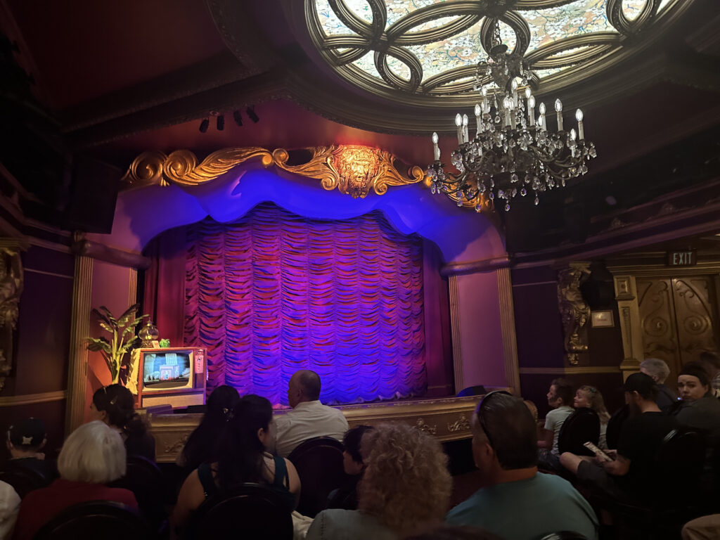 a group of people sitting in chairs watching a stage