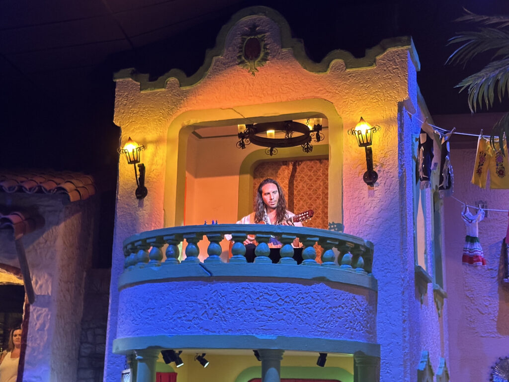 a man playing guitar in a balcony