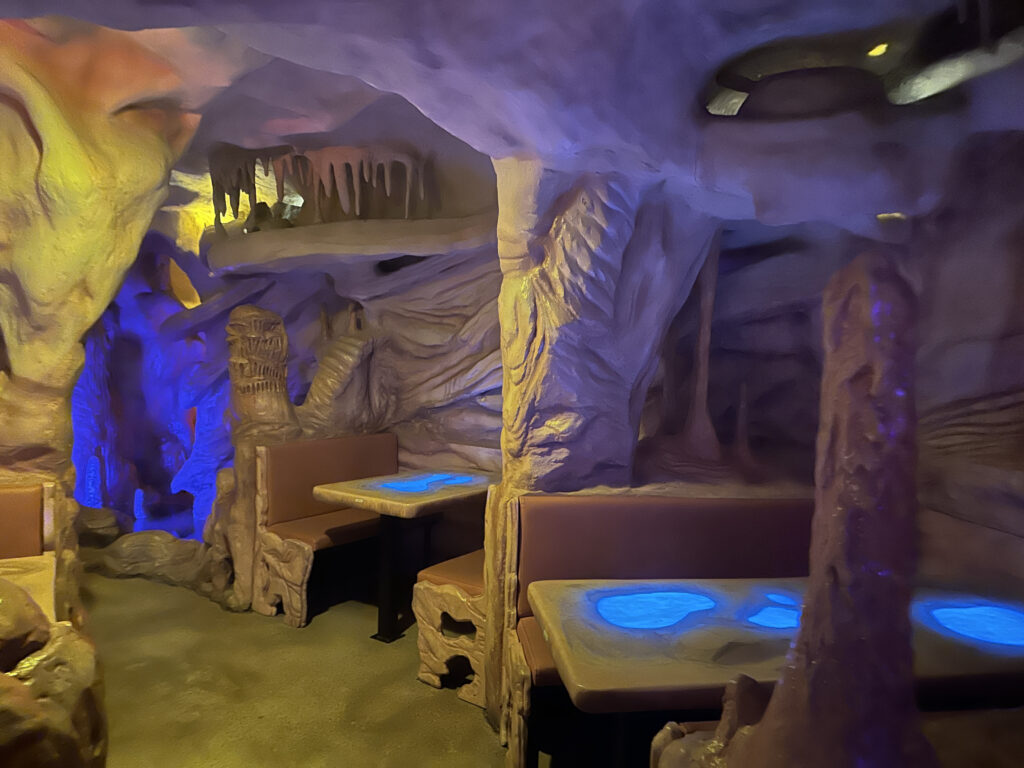 a room with tables and chairs in a cave