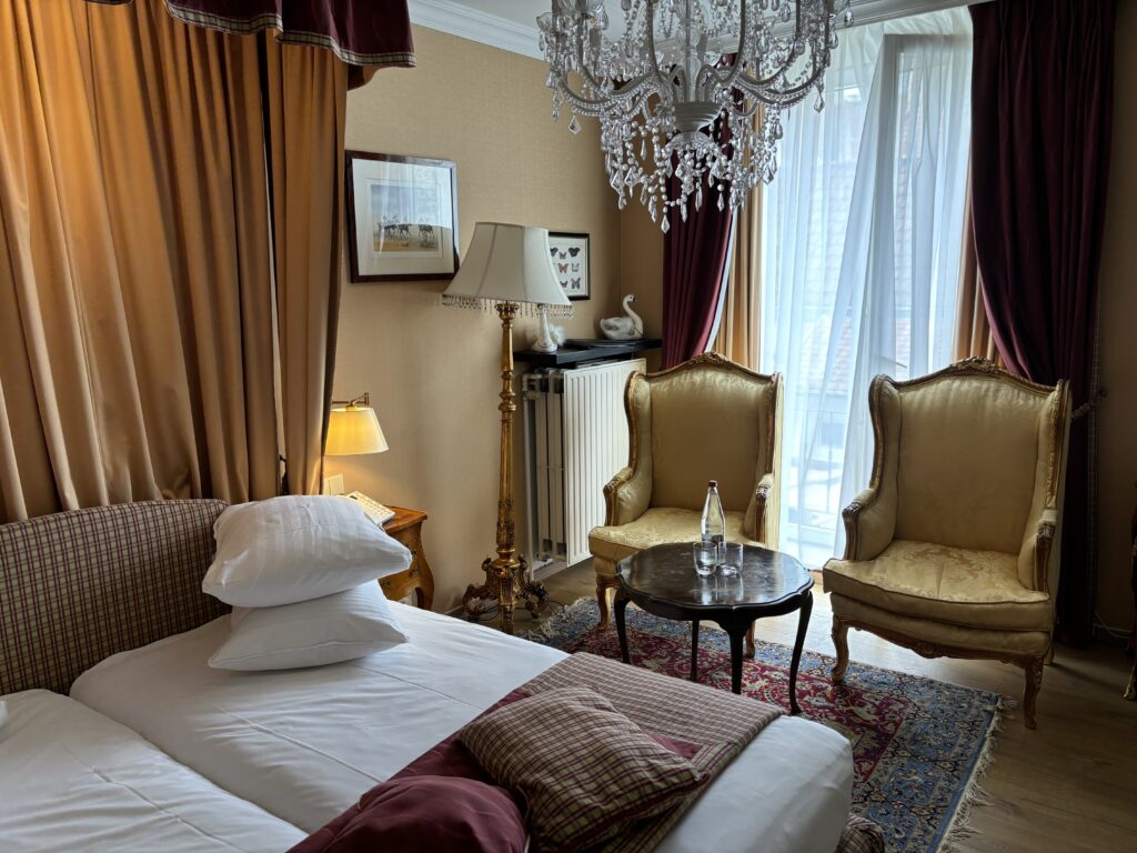 a room with a bed and chairs