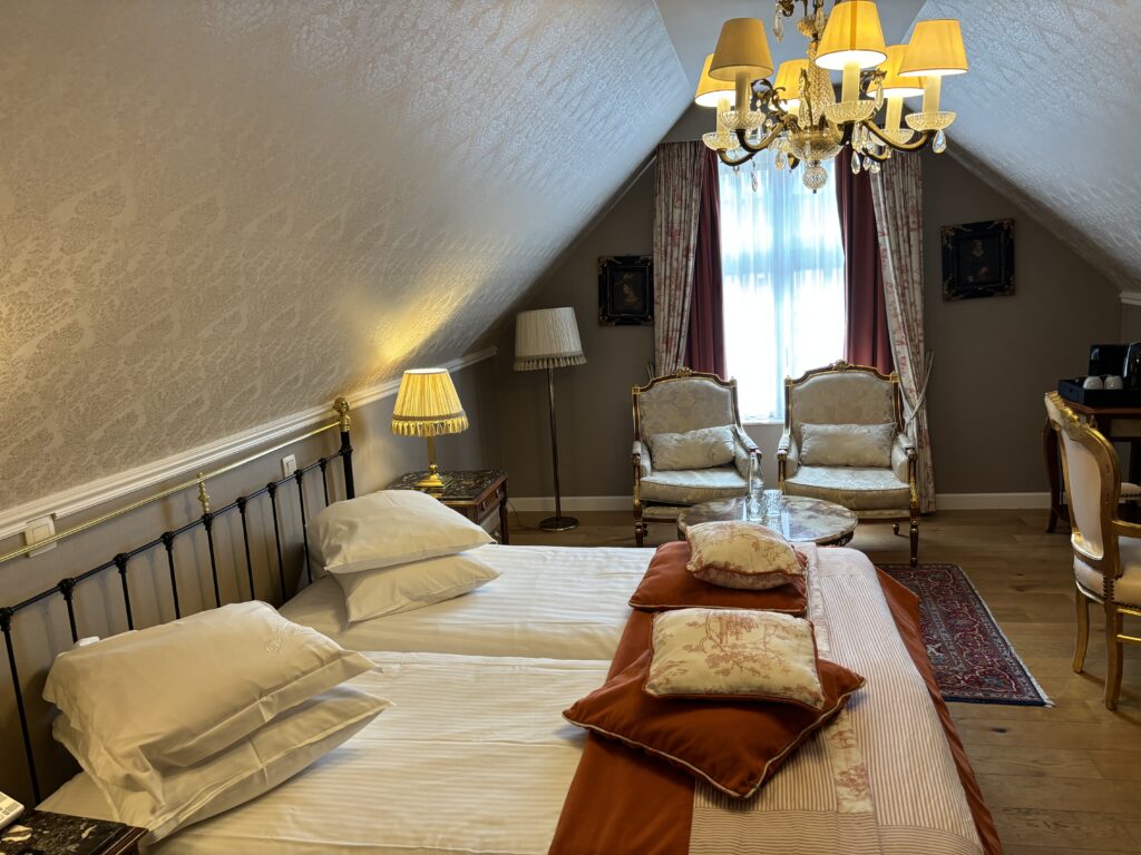 a bedroom with a chandelier and two chairs