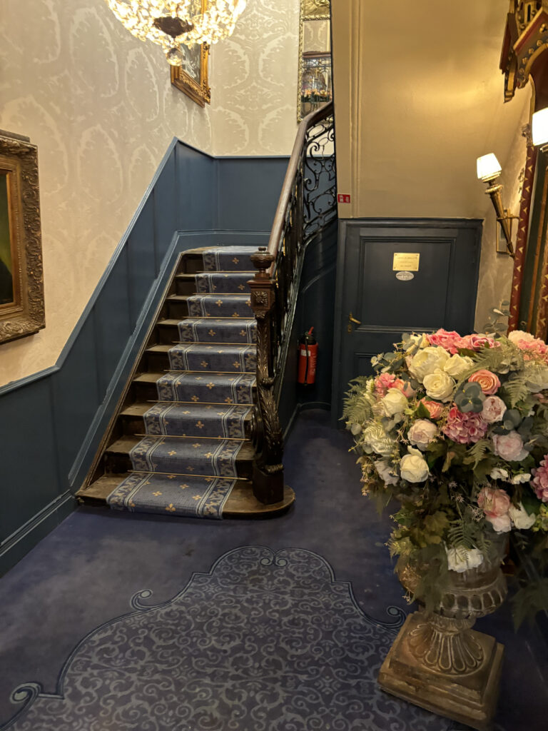 a staircase with blue carpet and flowers