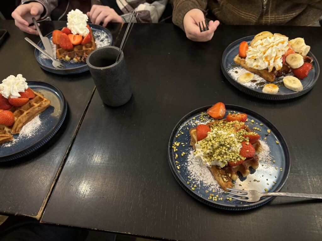 a group of people sitting at a table with plates of food