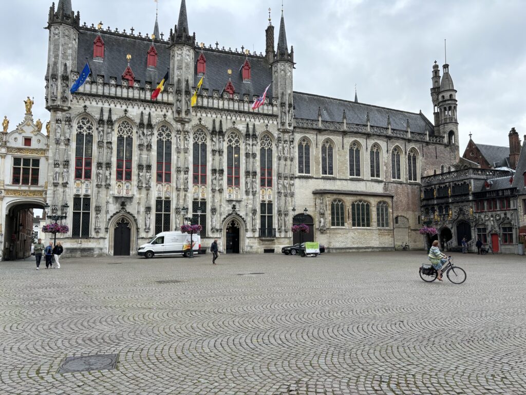 a large stone building with a large tower and a person on a bicycle