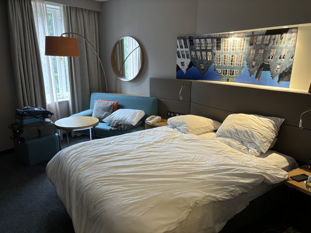 a bed with a couch and a lamp in a hotel room