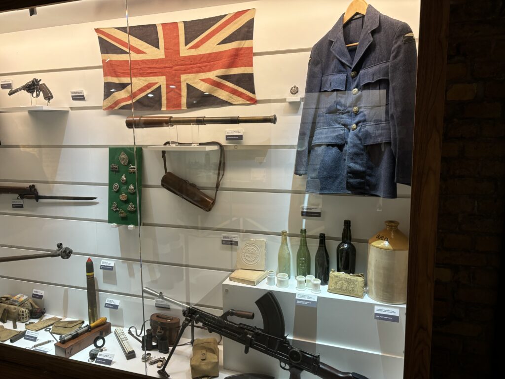 a display case with a flag and weapons