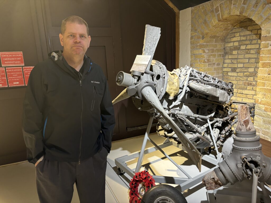 a man standing next to a propeller