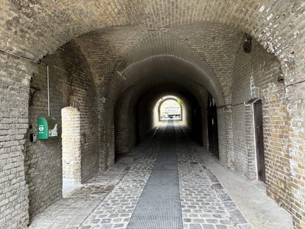 a brick tunnel with a green mailbox