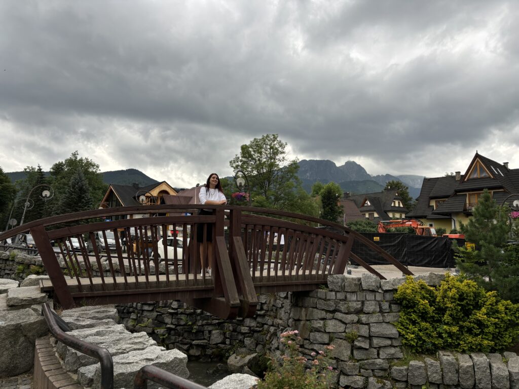 a woman standing on a bridge over a river
