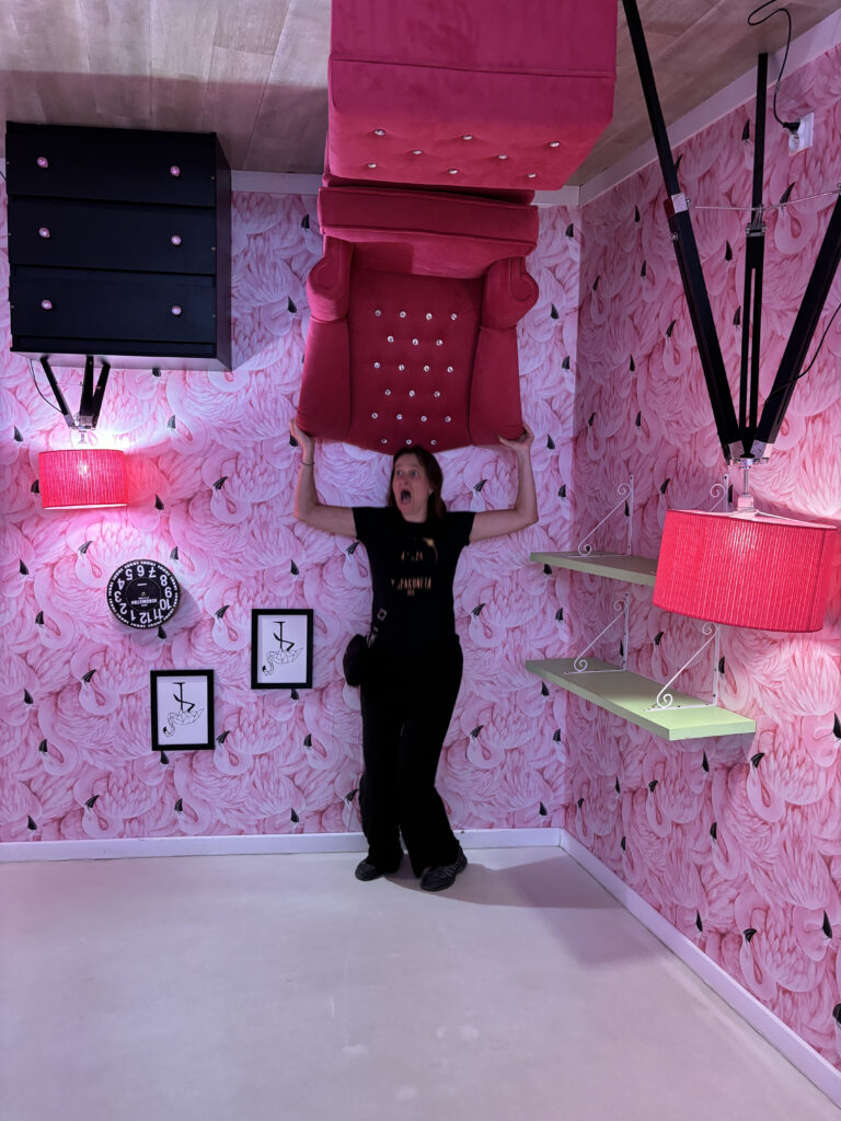 a woman standing in a room with a couch over her head