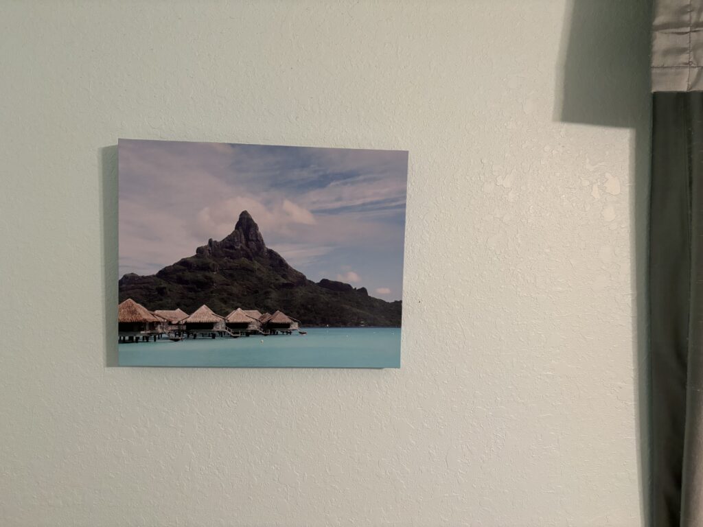 a picture of a mountain and huts on a wall