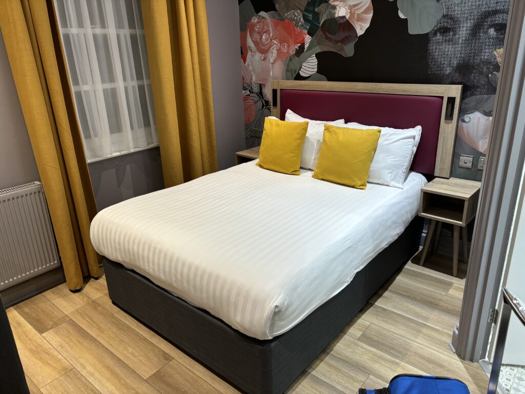 a bed with pillows and a wallpaper on the wall