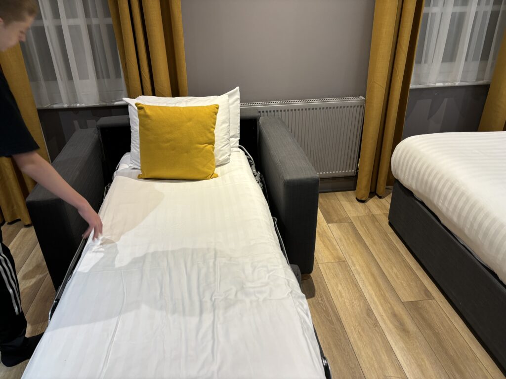 a person placing a bed on a couch