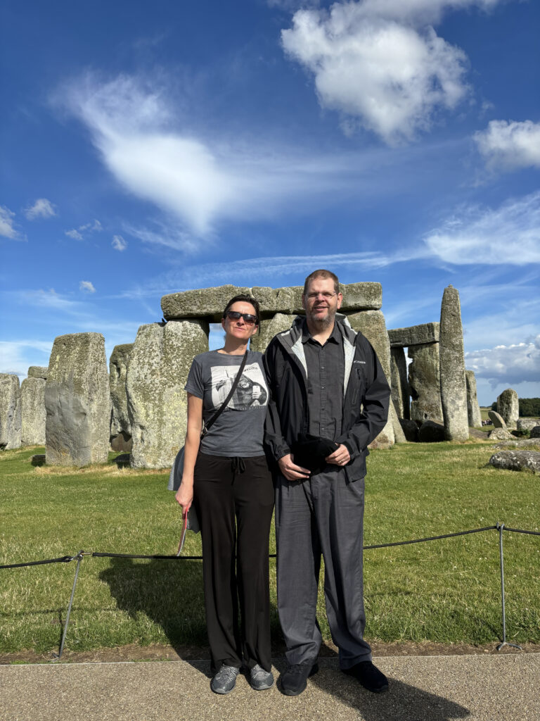 a man and woman standing in front of a stone monument